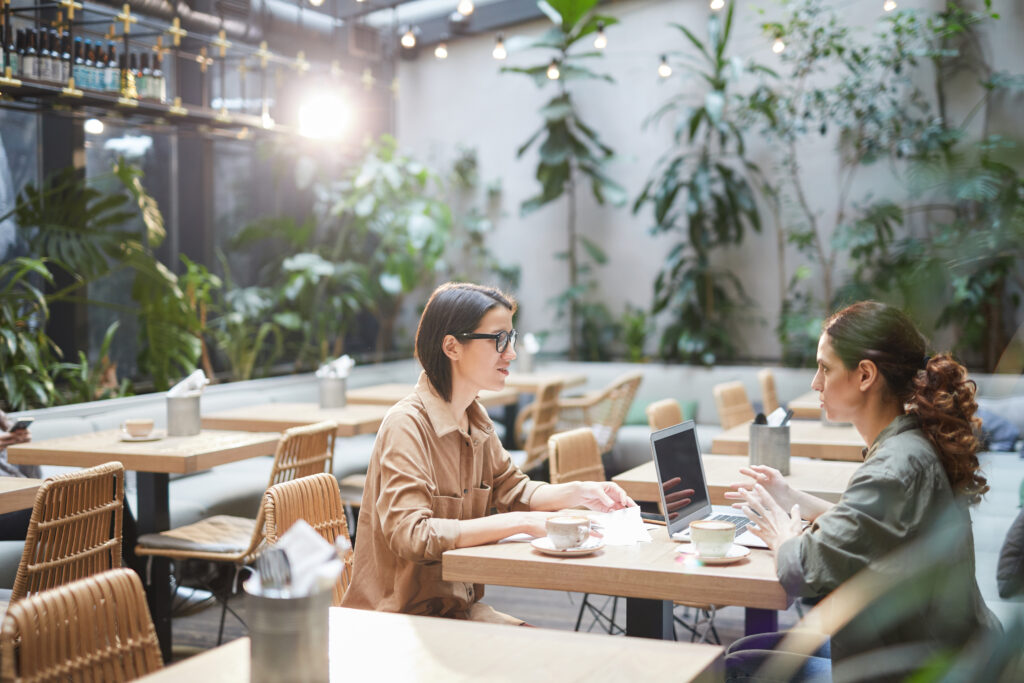young women discuss in a cafe